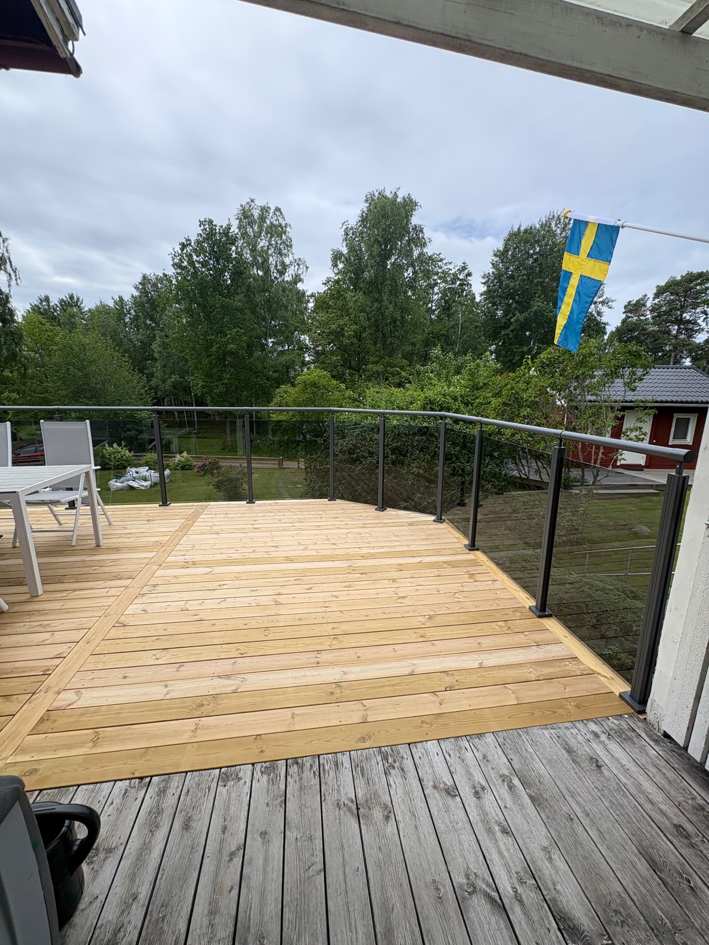 Nytt trädäck med glasräcke och utemöbler byggt av AW Bygg